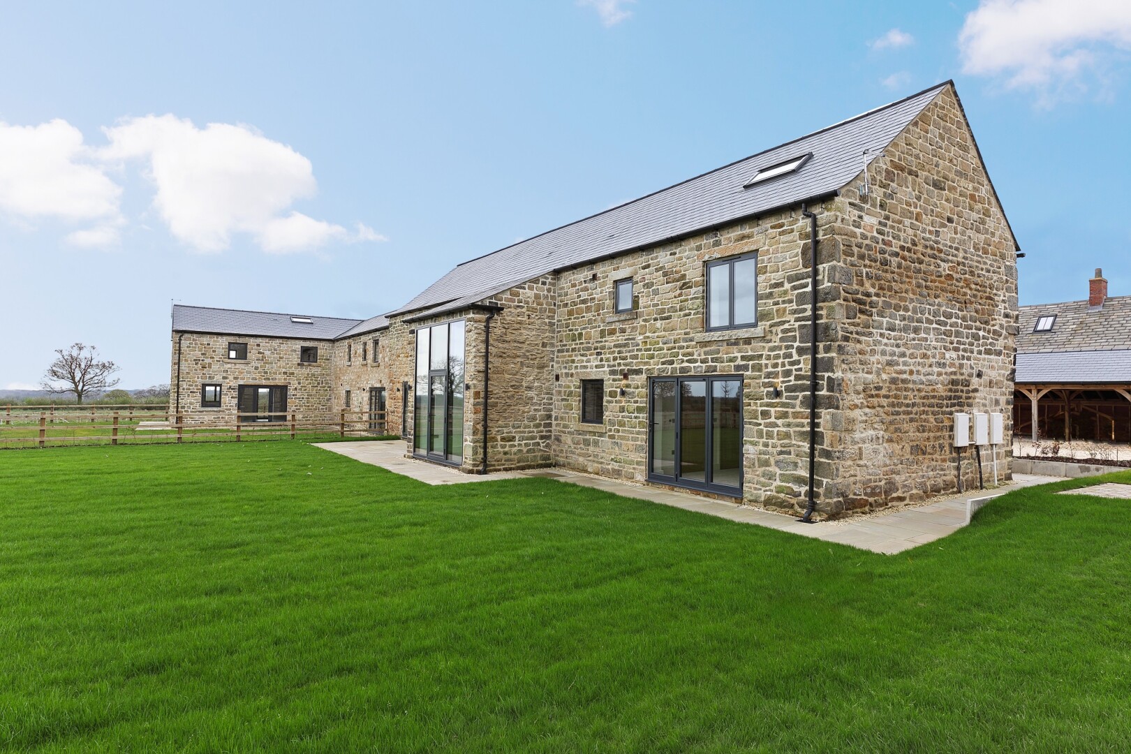Photograph of Saw Wood Barn, the converted barn at Flying Horse Farm in Scholes. The image shows a view of the rear of the building.