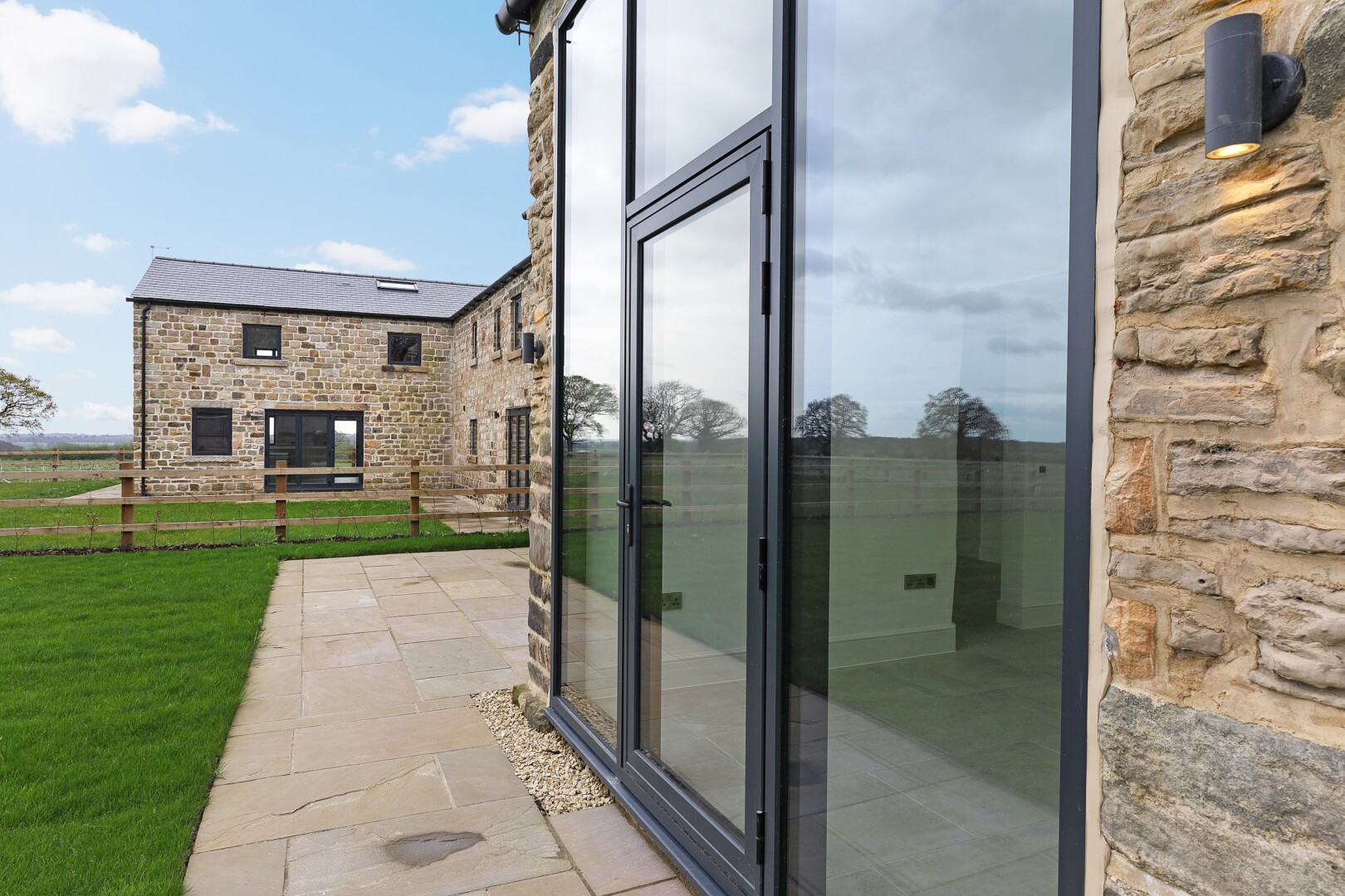 Photograph of Saw Wood Barn, the converted barn at Flying Horse Farm in Scholes. The image shows a view of the rear close of the building.