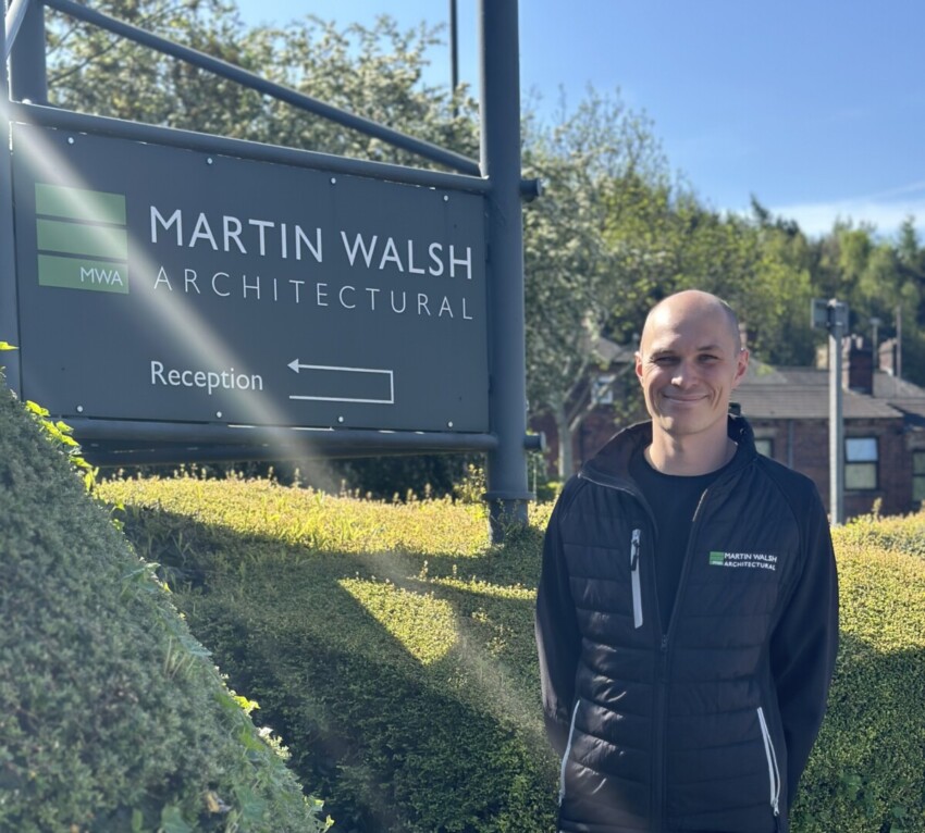 An image of David Hall, Martin Walsh Architectural's newest member who joins the team as a Chartered Architect, stood outside next to the Martin Walsh Architectural sign.